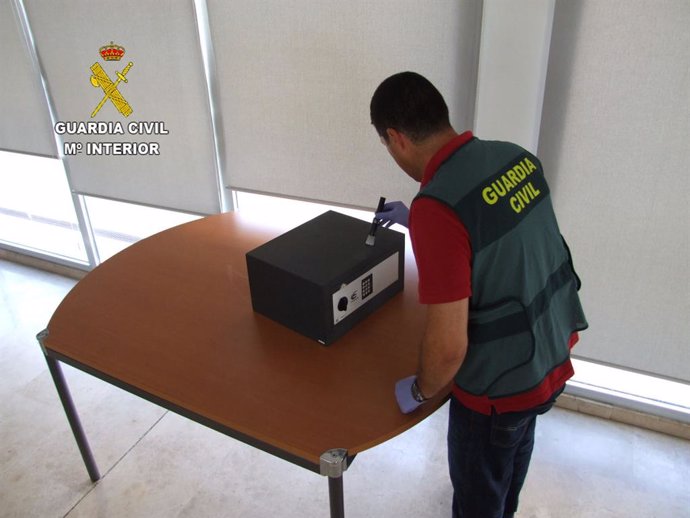 Agente de la Guardia Civil investigando la caja registradora del estanco atracado en Tomelloso