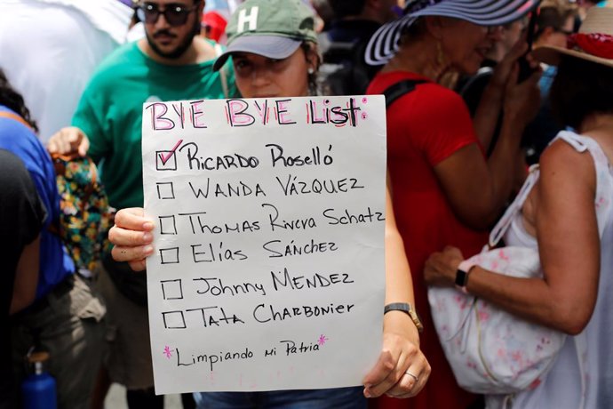 Una mujer sostiene una pancarta durante las protestas en Puerto Rico