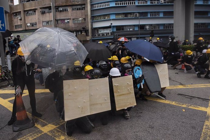 Manifestantes protegiéndose ante los agentes de la Policía de Hong Kong