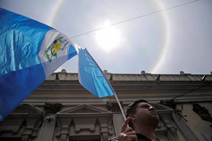 Un hombre ondea una bandera de Guatemala.