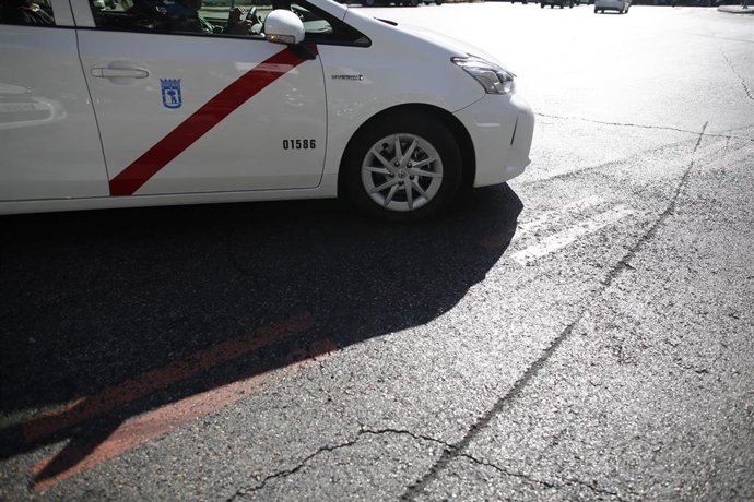 Una taxi pasa por encima de una línea naranja que indica restricción al tráfico en el centro de Madrid 