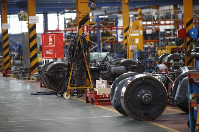 Unas ruedas de Metro en reparación en las instalaciones del Centro de Control de Metro de Madrid con una bandera del PSOE al fondo. 