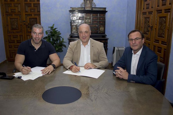 Antonio Ruiz (centro) firma el convenio de colaboración con el alcalde de La Carlota