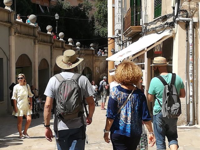 Turistas paseando por una calle céntrica de Palma.
