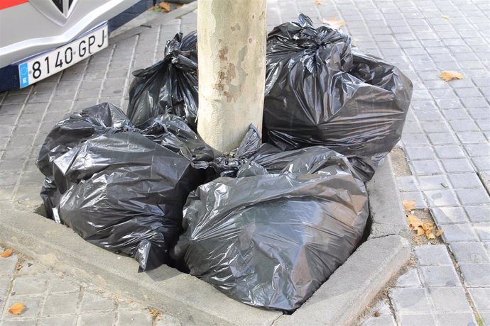 Conjunto de bolsas de basura,  tiradas en la calle.