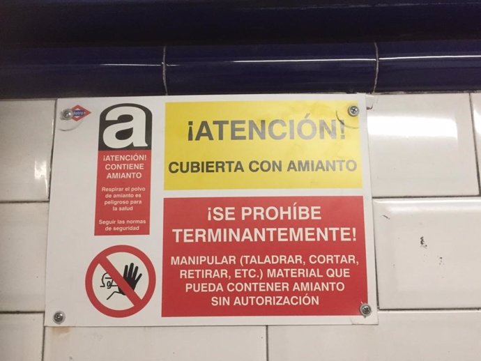 Cartel de Metro alertando de presencia de amianto en el pasillo de la línea 10 de la estación de Tribunal.
