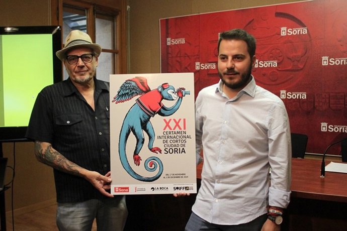 Javier Muñiz (I), director del Certamen, y el concejal de Juventud, Eder García, con el cartel ganador del Certamen Internacional de Cortos de Soria.