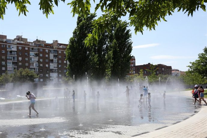 Varias personas, entre ellas niños, se refrescan en los chorros de Madrid Río un día antes de que, según la Agencia Estatal de Meteorología (AEMET), llegue a la península Ibérica y a las Islas Baleares la primera ola de calor del verano 2019.