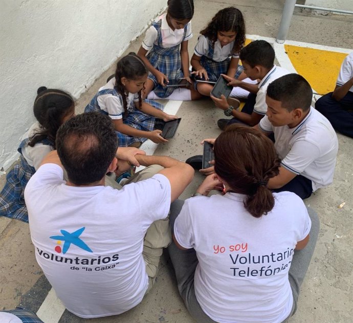 Voluntarios de Telefónica y La Caixa con un grupo de niños participantes en ProFuturo.