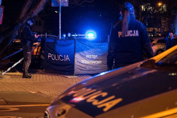 Agentes de Policía de Polonia junto con su coche asistiendo a un incidente
