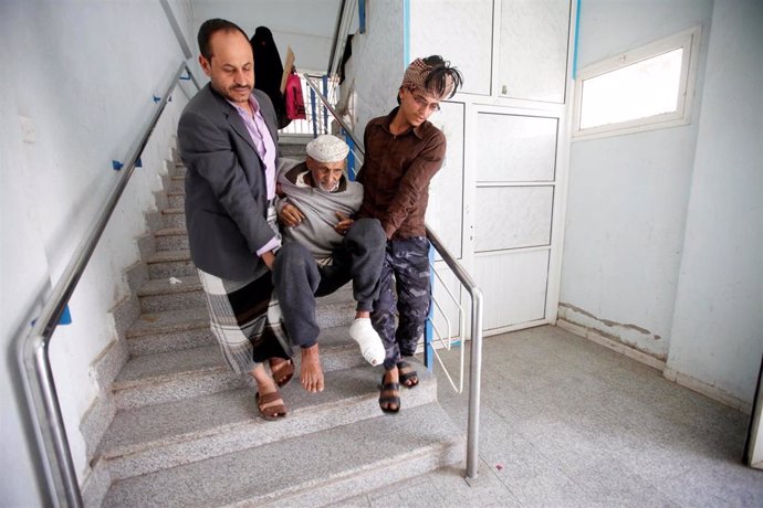 Personas cargando a un enfermo en Saná, Yemen