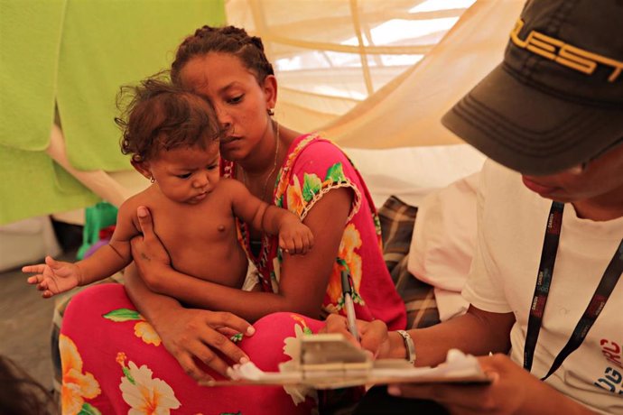 Mujer venezolana con su bebé en Colombia