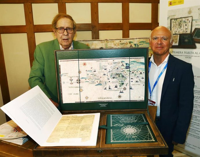 José María Sanz Hermida y Ramón Tamames con una copia de las ilustraciones de 'La Primera Vuelta la Mundo'