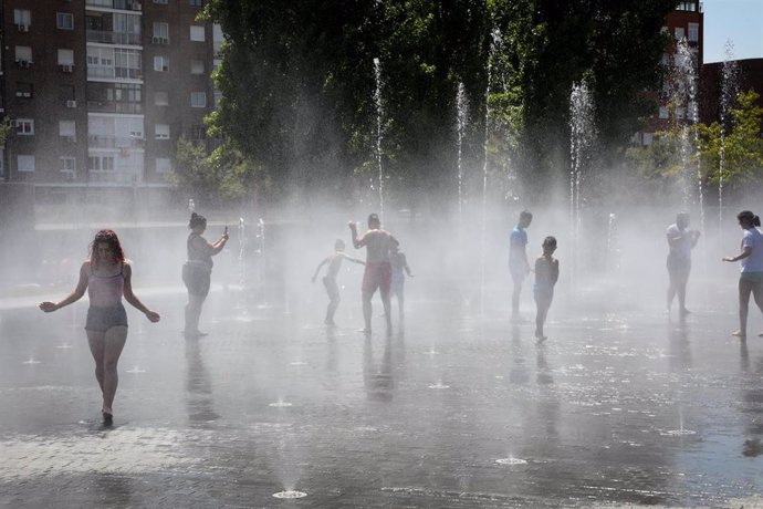 Varias personas, entre ellas niños, se refrescan en los chorros de Madrid Río un día antes de que, según la Agencia Estatal de Meteorología (AEMET), llegue a la península Ibérica y a las Islas Baleares la primera ola de calor del verano 2019.