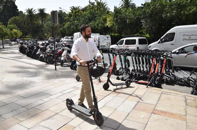 El portavoz del PSOE en el Ayuntamiento de Málaga, Daniel Pérez, con un patinete eléctrico en la ciudad.