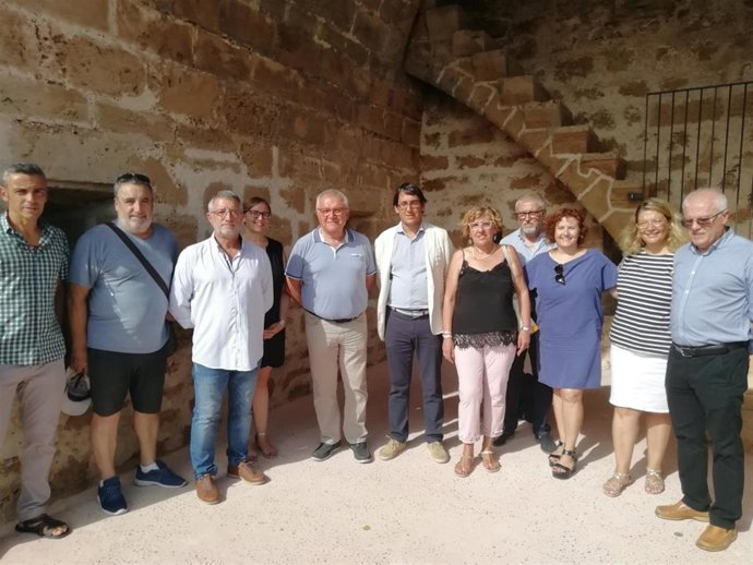 El conseller de Modelo Económico, Turismo y Trabajo, Iago Negueruela (6i) visita la muralla medieval de Alcúdia, rehabilitada con fondos del Impuesto de Turismo Sostenible (ITS).