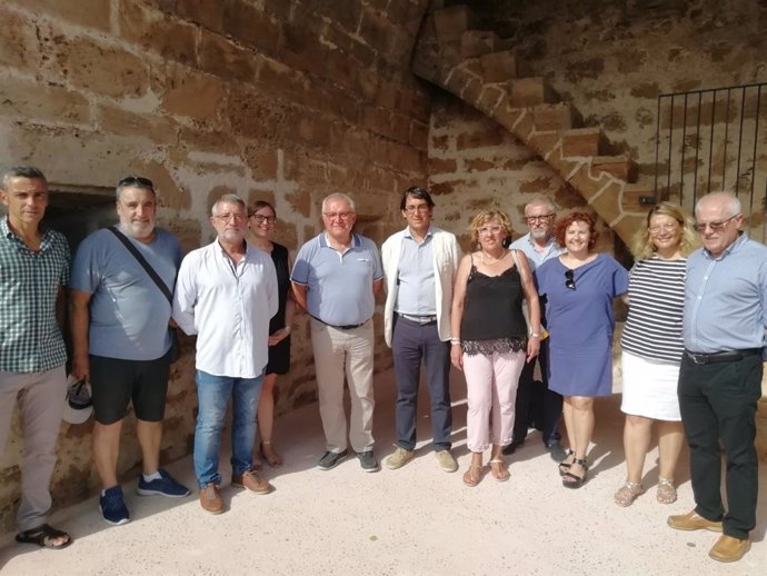 El conseller de Model Econmic, Turisme i Treball, Iago Negueruela (6i) visita la muralla medieval d'Alcúdia, rehabilitada amb fons de l'Impost de Turisme Sostenible (ITS).