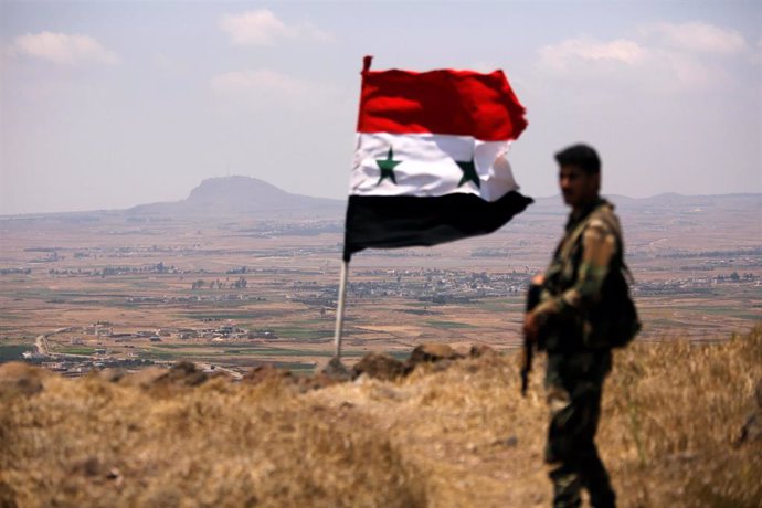 Un soldado sirio junto a la bandera nacional en Quneitra