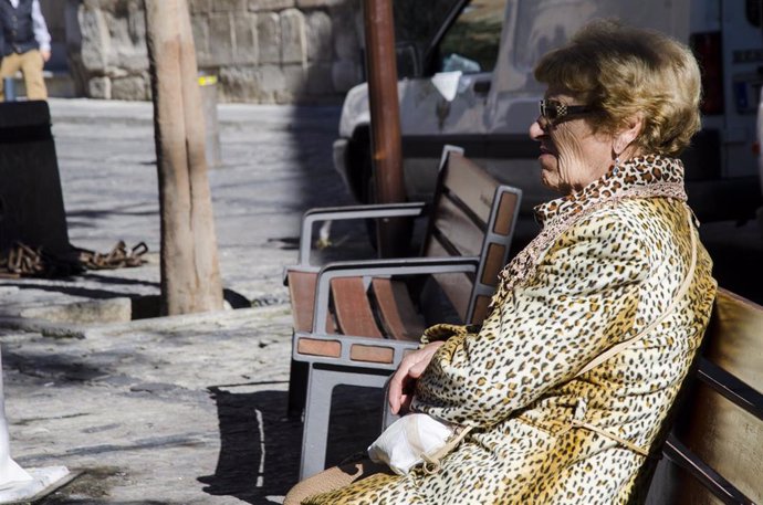 Persona de la tercera edad toma el sol en un parque