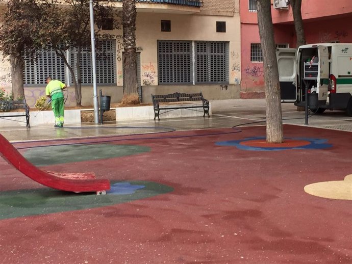 Un operario municipal realiza tareas de baldeo en la calle María Auxiliadora de Badajoz