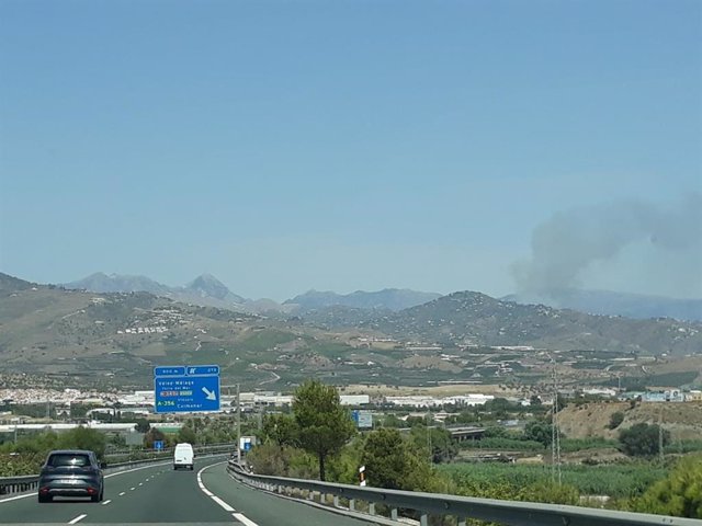 Imagen al fondo del incendio forestal declarado en Torrox (Málaga)