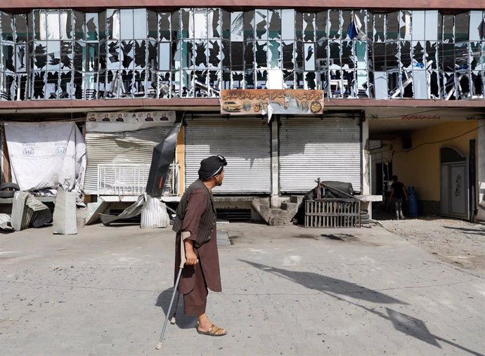 Un hombre con muleta pasea frente a un gimnasio destruido en Afganistán