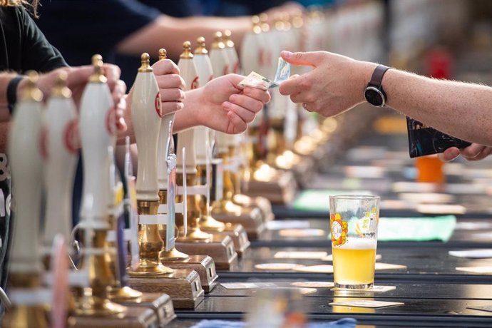 07 August 2019, England, London: A bar staff serves drinkers at the Great British Beer Festival 2019 at Olympia. Photo: Dominic Lipinski/PA Wire/dpa