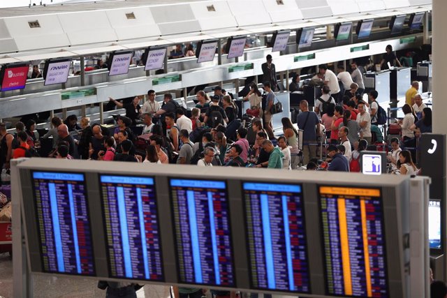 Pasajeros intentando hacer el check-in en el Aeropuerto Internacional de Hong Kong