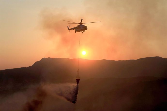 Un helicóptero apagando el fuego en un bosque de Evia, Grecia