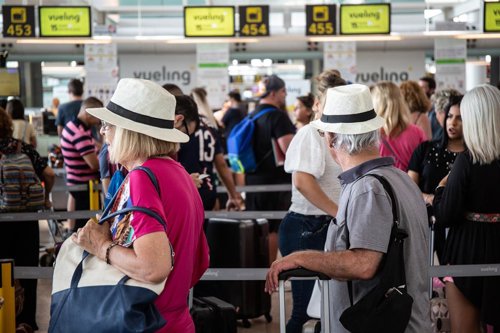 Diferentes viajeros esperan en el puesto de Check-In de la compañía Vueling en el Aeropuerto 'Josep Tarradellas Barcelona-El Prat', durante la huelga del personal de tierra de Iberia en Barcelona el pasado julio.
