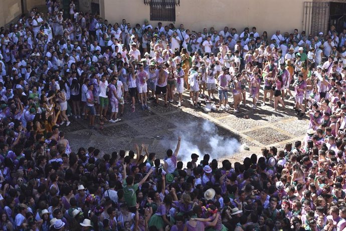Numerosos jóvenes vestidos de blanco y verde -y con ropa manchada de vino- celebran el inicio de las Fiestas de San Lorenzo en la Plaza de la Catedral de Huesca tras el tradicional chupinazo.
