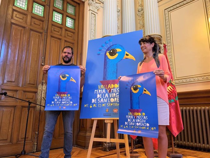 El autor del cartel de las Fiestas de Valladolid, Alberto Sobrino, y la concejal de Cultura y Turismo, Ana Redondo, sujetan la imagen de la celebración en honor a la Virgen de San Lorenzo.