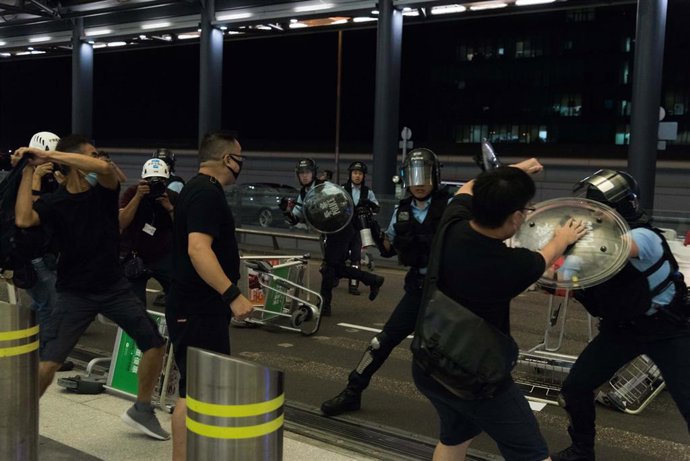 Enfrentamiento entre manifestantes y policías en el aeropuerto de Hong Kong