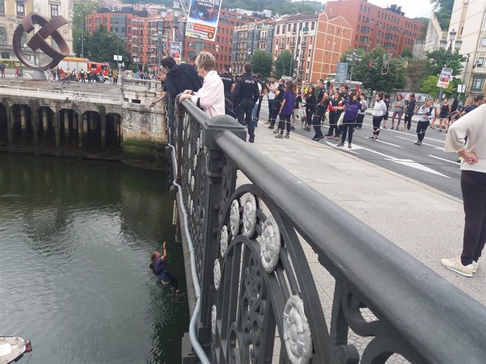 Bomberos izan a una feminista suspendida del puente del Ayuntamiento de Bilbao en una acción de protesta