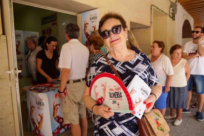 Una vecina de Almería con el abanico y el programa de las fiestas 2019