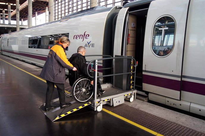 Servicio Atendo, personal ayuda a una persona con movilidad reducida a entrar en un tren AVE