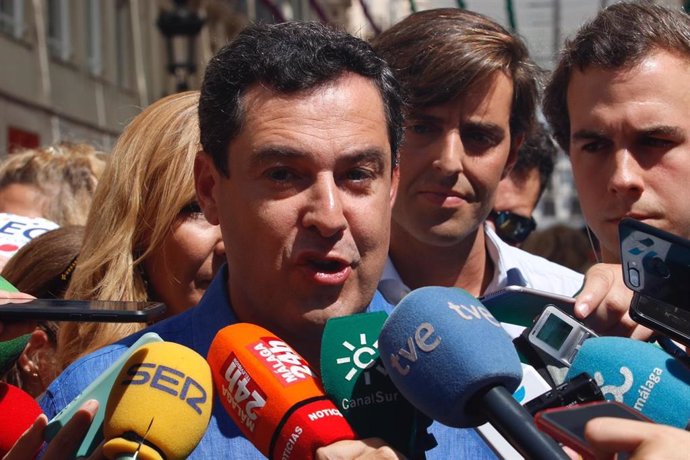 El presidente de la Junta de Andalucía y del PP andaluz, Juanma Moreno, atiende a los medios de comunicación en la Feria de Málaga.