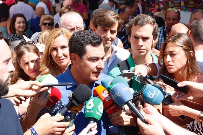 El presidente de la Junta de Andalucía, Juanma Moreno, atiende a los medios de comunicación en la Feria de Málaga