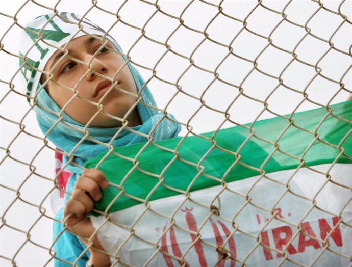 Una mujer iraní observa el entrenamiento de la selección nacional de fútbol de Irán detrás de una valla