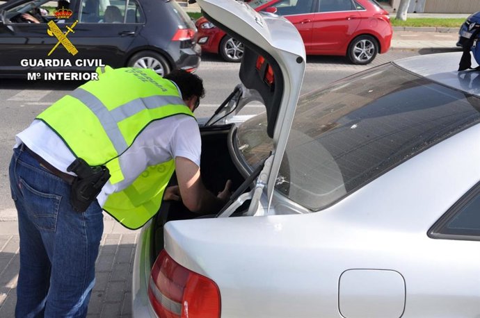 Un agente de la Guardia Civil inspecciona el maletero de un vehículo.