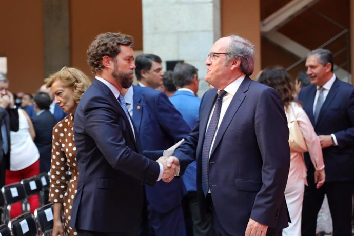(I-D) El portavoz de Vox en el Congreso de los Diputados, Iván Espinosa de los Monteros y el portavoz del PSOE en la Asamblea de Madrid, Ángel Gabilondo, se saludan durante el acto de toma de posesión del cargo de la presidenta de la Comunidad de Madrid.