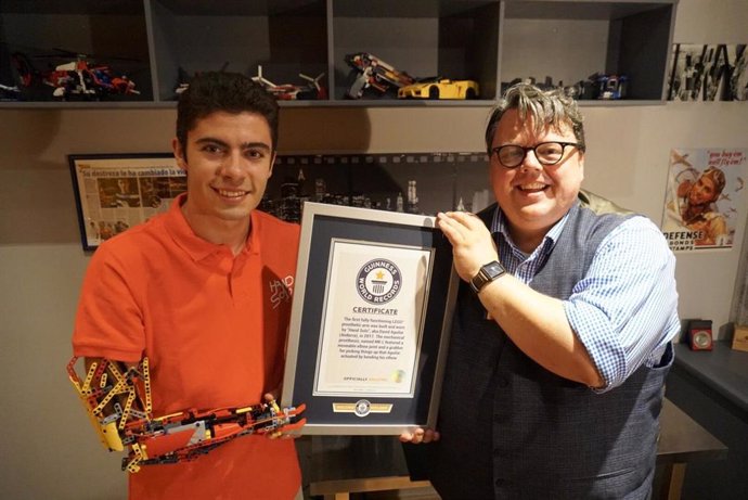 El editor jefe del Guinness World Records, Craig Glenday, entrega el certificado de reconocimiento al joven David Aguilar.