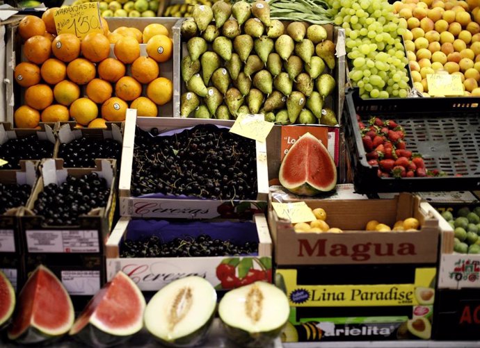 Naranjas, peras, limones, uvas, sandías, melones, fresas y cerezas en un mercado, una foto d earchivo.
