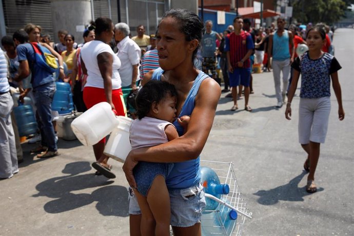 Mujer en busca de agua en Caracas