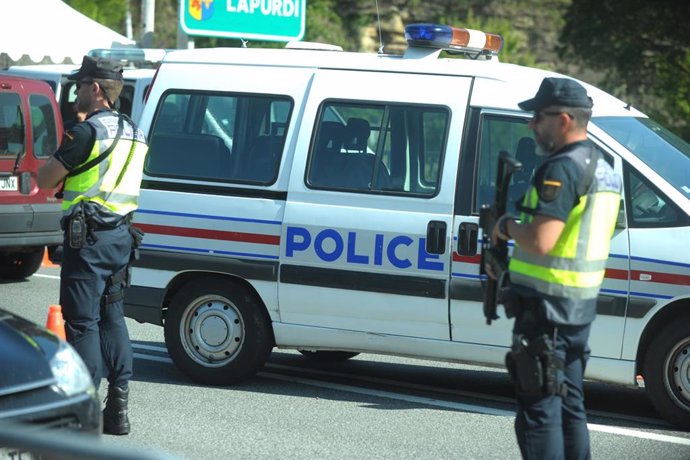 Dos agentes de la Policía Nacional, junto a una furgoneta de la Policía de Francia, en el punto de control de seguridad en el Puente de Behobia, en la frontera del País Vaco y Francia, con motivo la cumbre del G7 en Biarritz.