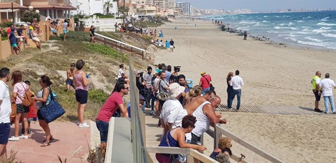 Vecinos y bañistas se acercan a la playa situada a la altura en la que se ha producido la caida del avión del Ejército del Aire, sobre el Mar Mediterráneo en La Manga del Mar Menor (Murcia).