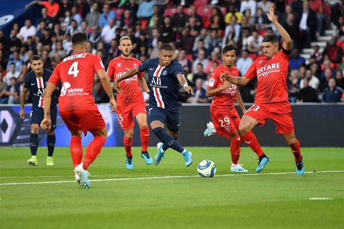 11 August 2019, France, Paris: Paris Saint-Germain's Killian Mbappe (C) battles for the ball with Nimes Olympique players during France Ligue one soccer match between Paris Saint-Germain F.C. and Nimes Olympique at Le Parc des Princes Stadium. Photo: Ju