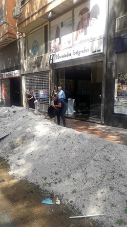 Vecinos de la localidad de Arganda del Rey retiran restos generados por la fuerte tormenta en la Comunidad de Madrid.
