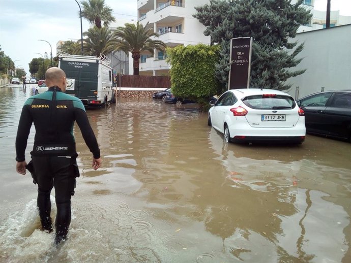Un agente camina en una carretera afectada por una inundación en el sur de Mallorca.