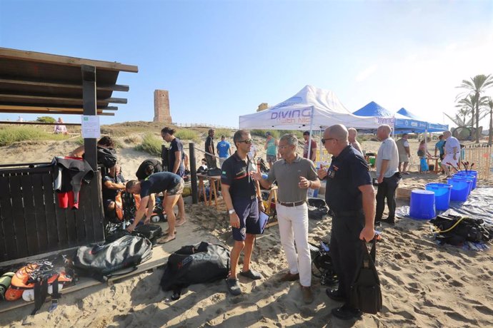 Miembros de Bomberos, Protección Civil y de diferentes colectivos participan en la limpieza de la playa Cabopino convocada por la Asociación ProDunas.